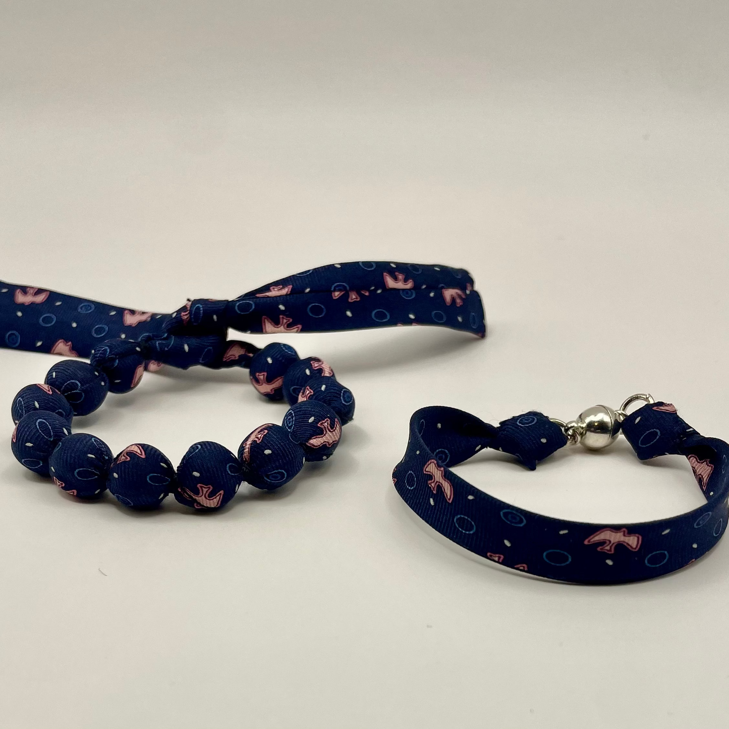 Bracelet perles de soie bleu marine et rose motif hirondelles